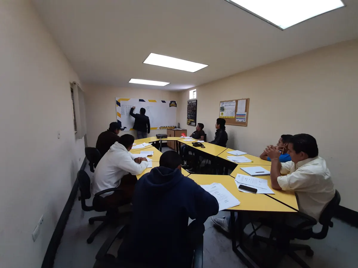 Grupo de colaboradores en un taller práctico frente a una pizarra