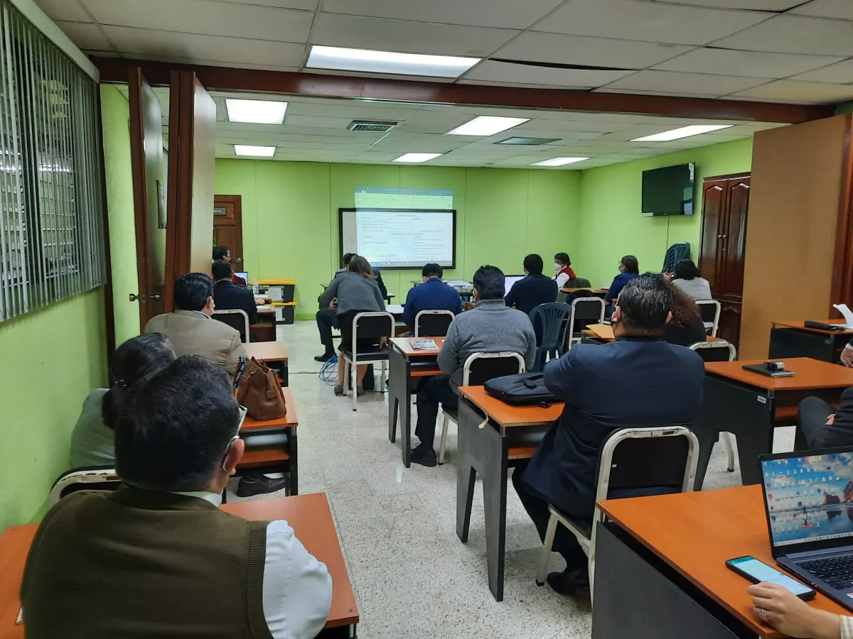 Personal administrativo atendiendo una capacitación presencial en un aula
